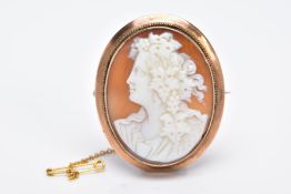 A YELLOW METAL CAMEO BROOCH, of an oval design depicting a lady in profile, within a collet mount