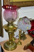 A BRASS OIL LAMP, with clear funnel and ruby coloured wavy edged glass shade, total height to top of