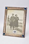 A SILVER LINED PHOTO FRAME, of a rectangular form, with each corner set with a round blue and