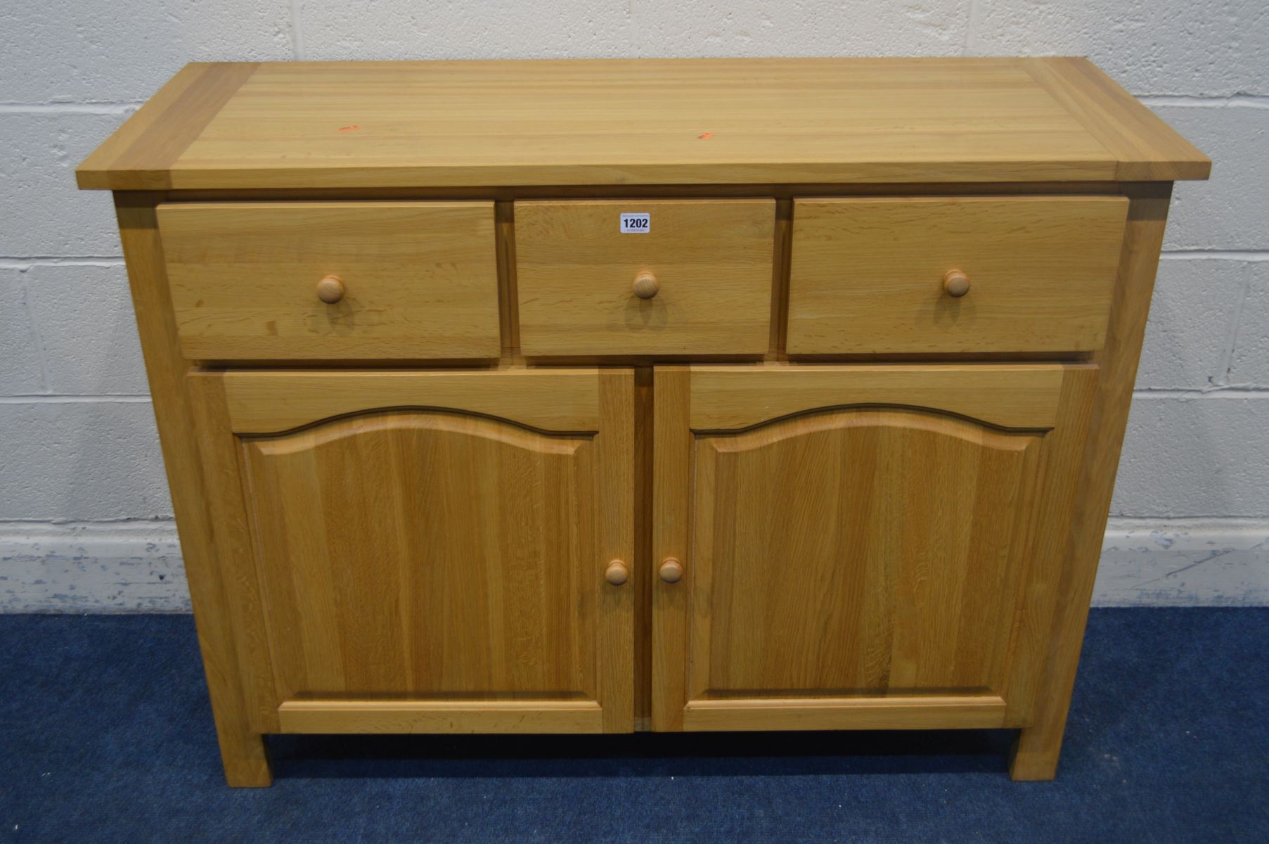 A SOLID LIGHT OAK SIDEBOARD, with three drawers, width 120cm x depth 45cm x height 90cm