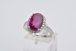 AN IMPRESSIVE MODERN 18CT WHITE GOLD RUBY AND DIAMOND OVAL CLUSTER RING, centring on a large oval