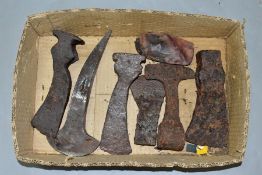 A BOX CONTAINING SIX ANCIENT IRON AXE HEADS, possibly Roman and Bronze Age, and a flint axe head,