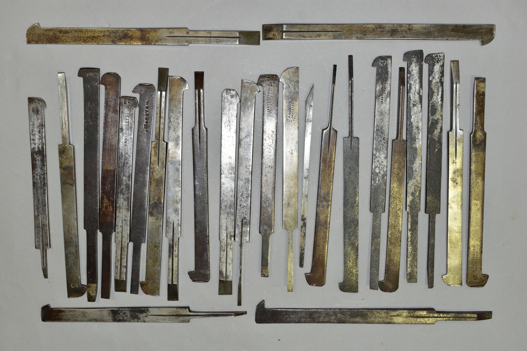 A TRAY CONTAINING TWENTY SIX VINTAGE PLOUGH PLANE IRONS by Ibbotson, Hildick, A Drew, Atkin etc