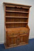 A 19TH CENTURY AND LATER PINE SLOPPED BOOKCASE, the three tier open top above two drawer and