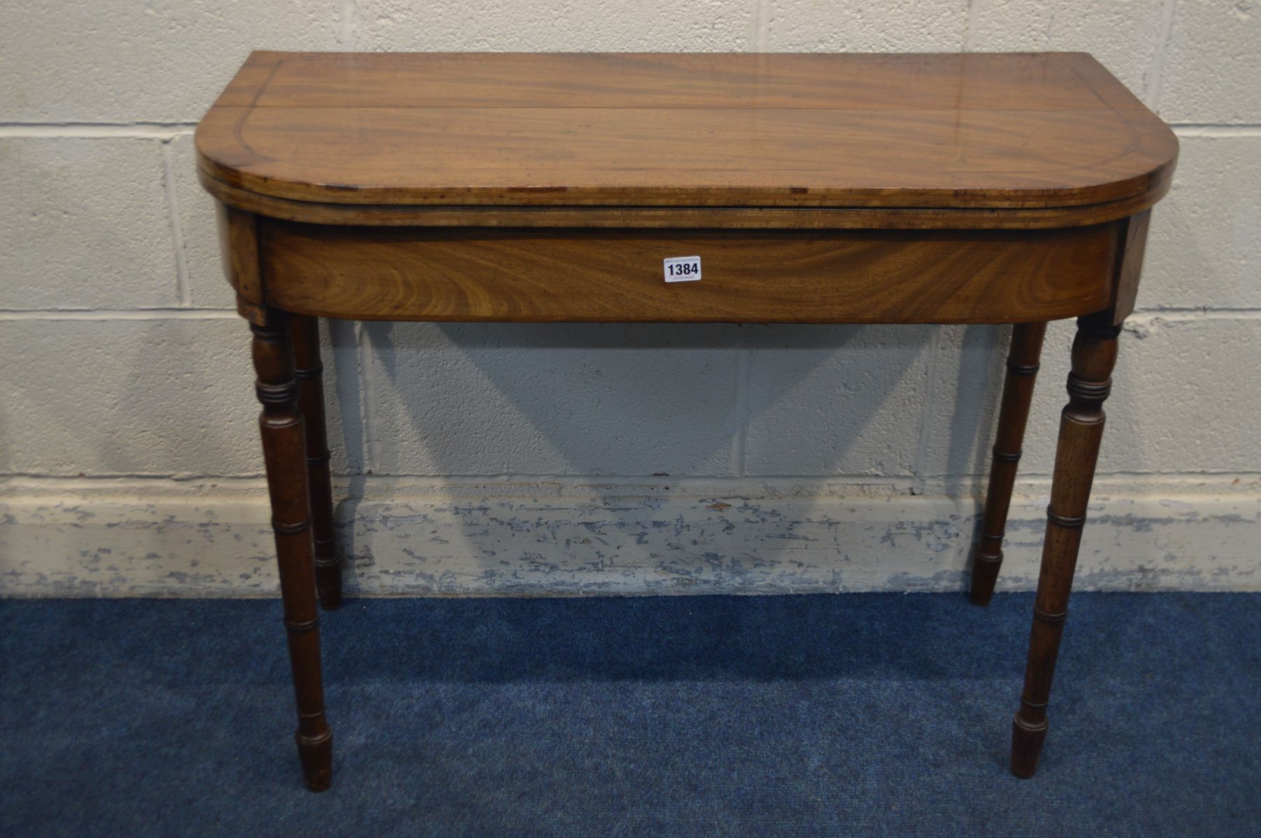 A GEORGIAN MAHOGANY CARD TABLE, the fold over top with a green baize lining, on turned legs, width