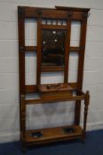 AN EDWARDIAN WALNUT HALL STAND, with six hooks but one hook missing, central bevelled mirror, hinged