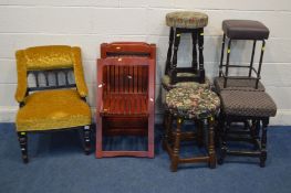 A LATE VICTORIAN AESTHETIC MOVEMENT CHAIR with sloped armrests, along with four folding chairs and