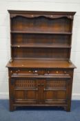 A REPRODUCTION OAK DRESSER, with two shelf plate rack, two drawers and double cupboard doors,