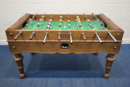A FUTBOLIN UK MAHOGANY TABLE FOOTBALL GAME, with painted metal players, playing in white and yellow,