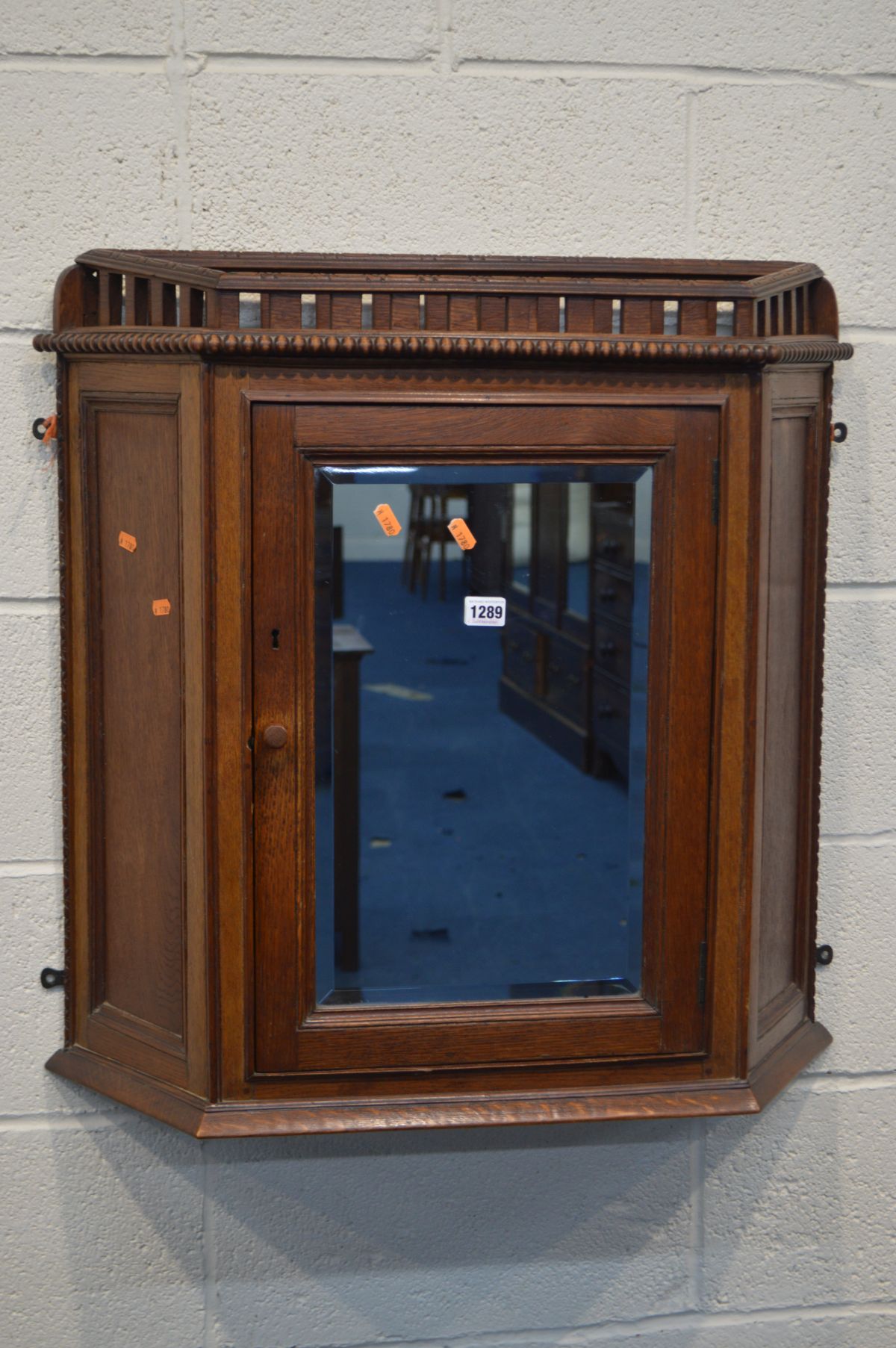 A LATE 19TH/EARLY 20TH CENTURY OAK CANTED SINGLE DOOR HANGING WALL CABINET with beading and