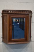 A LATE 19TH/EARLY 20TH CENTURY OAK CANTED SINGLE DOOR HANGING WALL CABINET with beading and