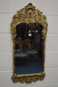 A GILT METAL COMPOSITION ROCOCO STYLE WALL MIRROR, with scrolling acanthus leaves, 46cm x 100cm