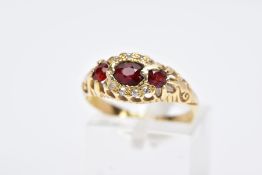 AN EARLY 20TH CENTURY 18CT GOLD BOAT RING, designed with a central oval cut garnet, within a