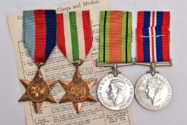 A BAG OF FOUR WWII MEDALS 1939-1945, ITALY STARS, DEFENCE AND WAR MEDAL with issue slip, un-named as