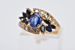 A MODERN SAPPHIRE AND DIAMOND DRESS RING, crossover design centering on an oval blue sapphire,