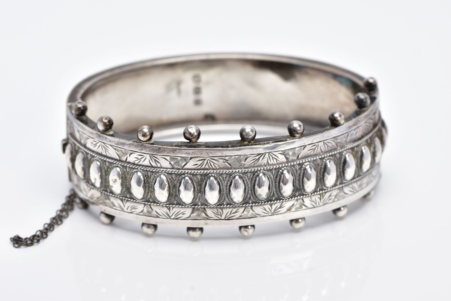 A VICTORIAN SILVER BANGLE, applied bead word decoration and half engraved, measuring 20.0mm in