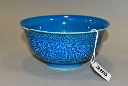 A CHINESE PORCELAIN BLUE GROUND BOWL, moulded in relief to the exterior with flowers, scrolls and