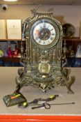 A LATE VICTORIAN BRASS CASED MANTEL CLOCK, the caddy top and one scrolled side arm loose,