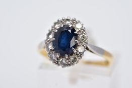 A YELLOW METAL SAPPHIRE AND DIAMOND CLUSTER RING, designed with an oval cut claw set blue sapphire