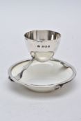 A GEORGE V SILVER AND CERAMIC EGG CUP, designed with a plain polished egg cup hallmarked 'Hukin &