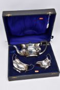 A CASED GEORGE V SILVER THREE PIECE TEA SET, of oval form with fanned panelled decoration,