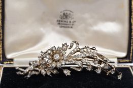 A GOLD VICTORIAN DIAMOND FLOWER SPRAY BROOCH, mounted en tremblant, the larger old cushion cut