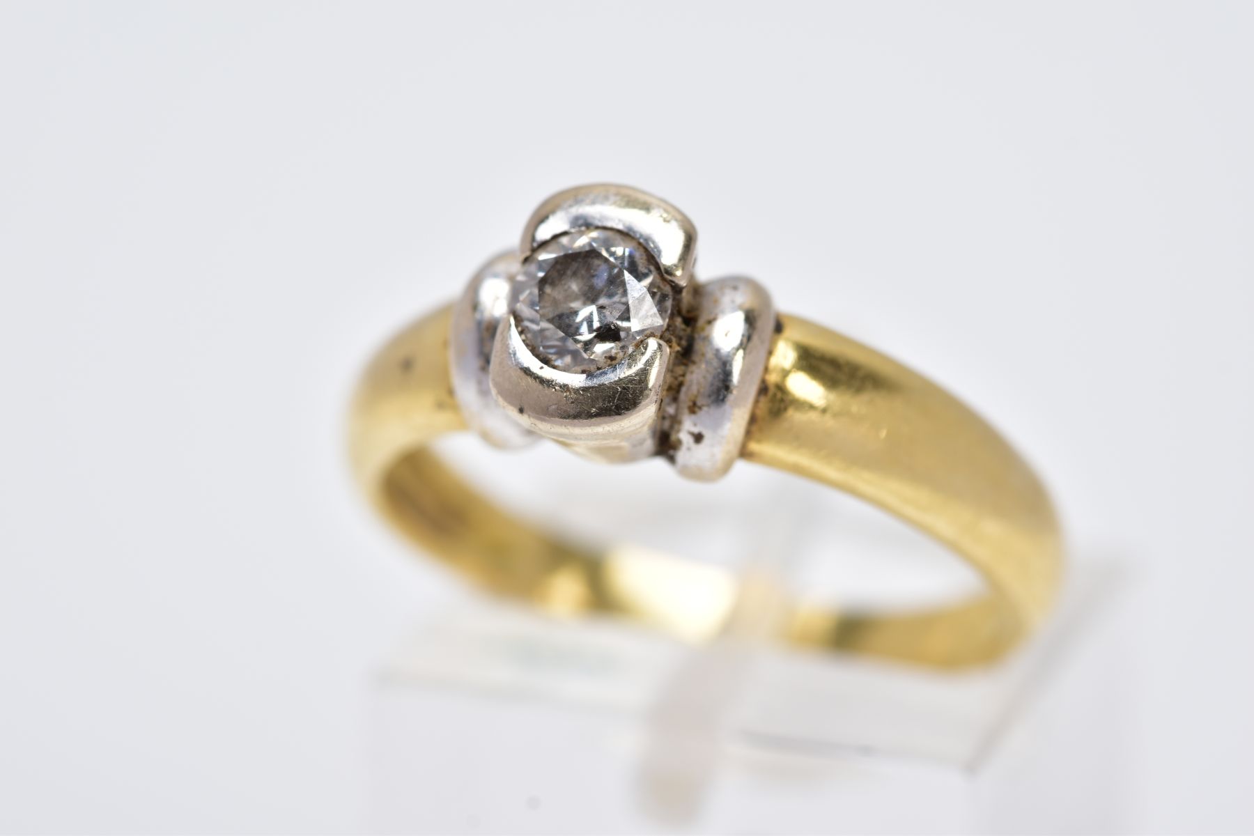 A YELLOW METAL SINGLE STONE DIAMOND RING, designed with a round brilliant cut diamond within a