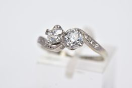 AN EARLY TO MID 20TH CENTURY TWO STONE DIAMOND CROSSOVER RING with diamond set shoulders, the two