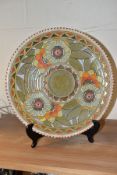 A CHARLOTTE RHEAD FOR CROWN DUCAL CHARGER, early 20th Century, the stylised floral centre surrounded
