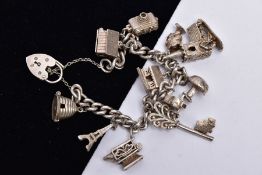 A SILVER CHARM BRACELET, suspending eleven charms in forms such as a bee hive, camera, key, mushroom