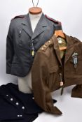 THREE MILITARY UNIFORM JACKETS to include a WWII era short battle smock with para wings medal