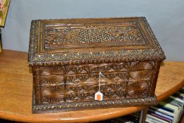 A 19TH CENTURY HEAVILY CARVED OAK TEA CADDY, hinged lid opening to reveal two fixed rectangular