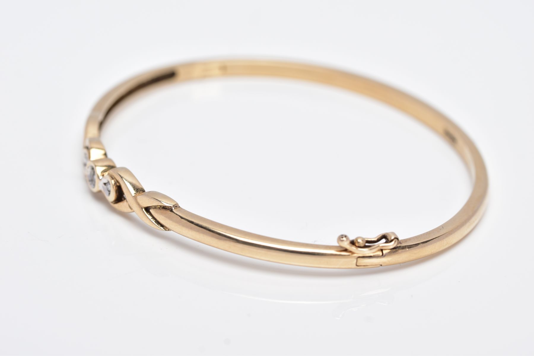 A 9CT GOLD DIAMOND BANGLE, designed with a crossover section set with three round brilliant cut - Image 2 of 5