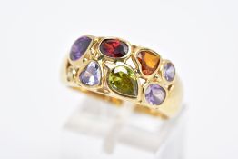 A YELLOW METAL RING, a wide band set with eight various cut coloured stones, assessed as orange