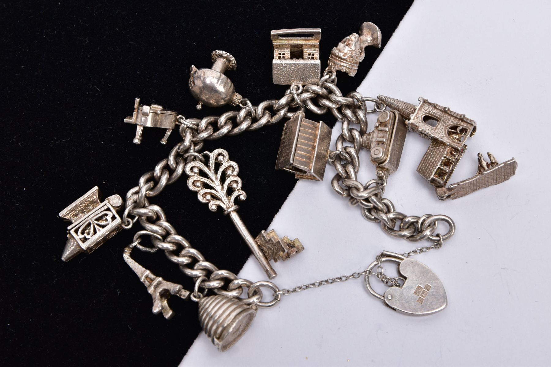 A SILVER CHARM BRACELET, suspending eleven charms in forms such as a bee hive, camera, key, mushroom - Image 2 of 2