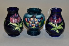 THREE SMALL MOORCROFT VASES, comprising a pair of baluster vases decorated with red/pink anemone