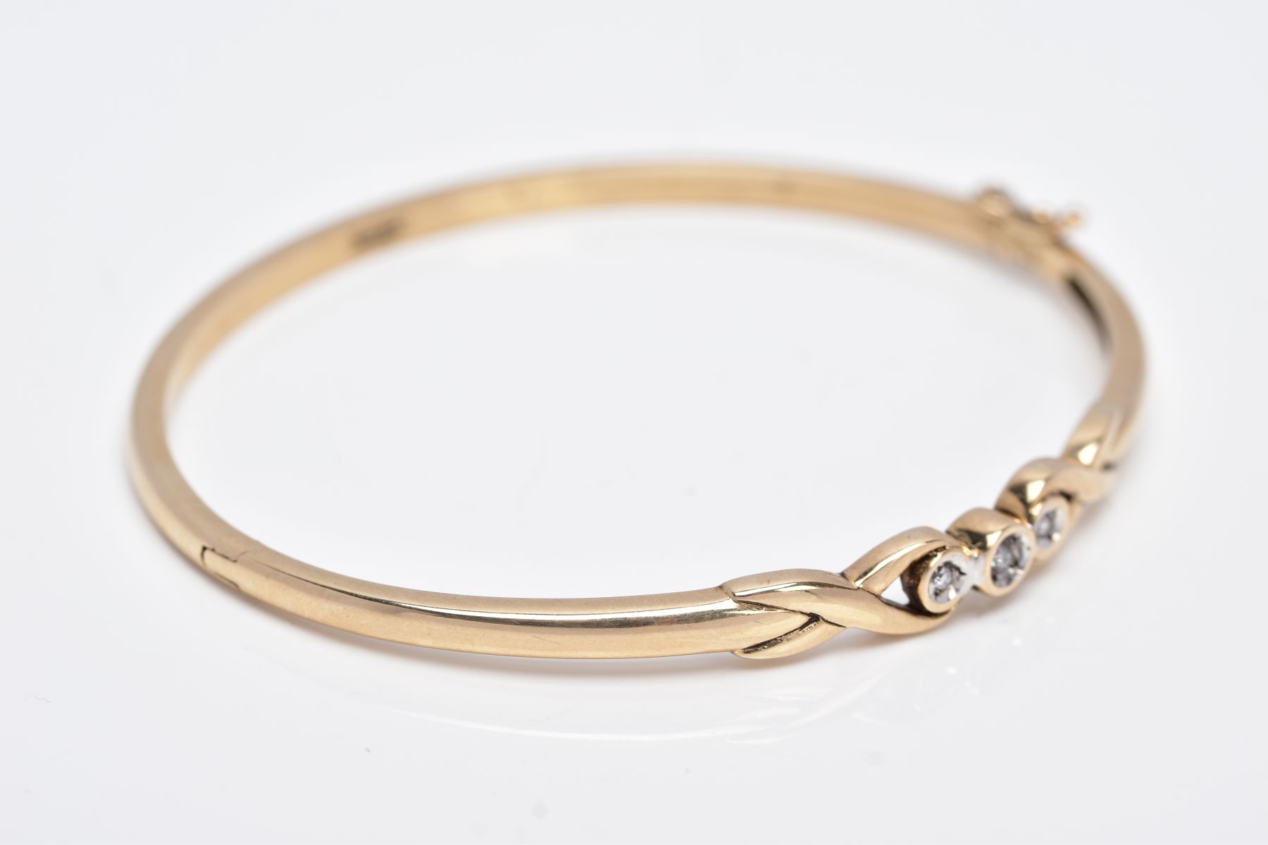 A 9CT GOLD DIAMOND BANGLE, designed with a crossover section set with three round brilliant cut - Image 4 of 5