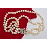 A CULTURED PEARL NECKLET, two strands of cultured pearls, individually knotted on a white cord, each