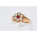 A YELLOW METAL OPAL CLUSTER RING, designed with a central circular cut red stone assessed as