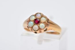 A YELLOW METAL OPAL CLUSTER RING, designed with a central circular cut red stone assessed as