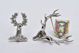 TWO WHITE METAL BROOCHES AND A JUBILEE PLAQUE, the first brooch in the form of a stag head,