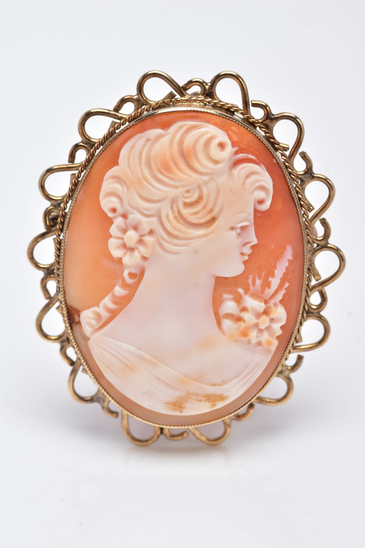 A 9CT GOLD CAMEO BROOCH, of an oval form, depicting a lady in profile, within a millegrain setting