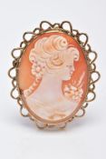 A 9CT GOLD CAMEO BROOCH, of an oval form, depicting a lady in profile, within a millegrain setting