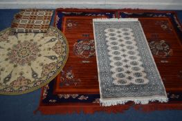 A PAIR OF MODERN RED GROUND RUGS, 200cm x 125cm, a circular rug, a tekke rug and a bed throw (5)