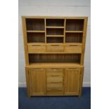 A LIGHT OAK DRESSER with an assortment of shelves, drawers and led lighting, above a base with two