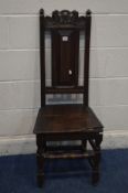 A GEORGIAN OAK HALL CHAIR with a carved top rail, and front stretcher (missing front right par of