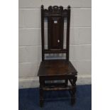 A GEORGIAN OAK HALL CHAIR with a carved top rail, and front stretcher (missing front right par of