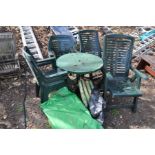 A GREEN PAINTED METAL CIRCULAR GARDEN TABLE on shaped legs together with four green plastic stacking