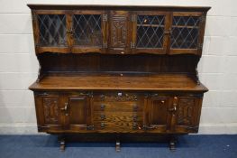 AN OAK DRESSER, with lead glazed panel cupboard top and four drawers, width 187cm x depth 43cm x