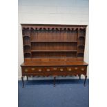 AN IMPRESSIVE GEORGE III OAK DRESSER, the plate rack with moulded cornice, wavy apron, arrangement